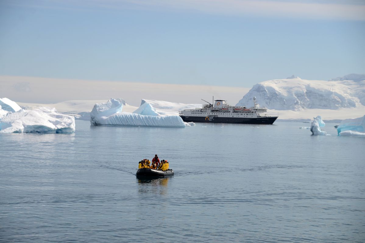 20A Zodiac Coming In To Land On Cuverville Island With Brabant Island And The Quark Expeditions Antarctica Cruise Ship Beyond